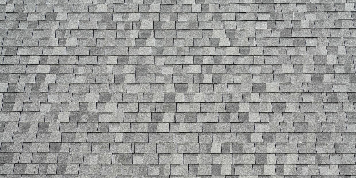 Close-up of a gray shingle roof with overlapping rectangular tiles.