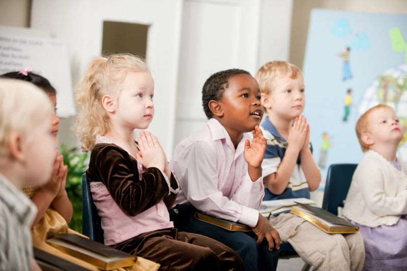 A group of multi-ethnic children at Sunday School in a real church classroom.