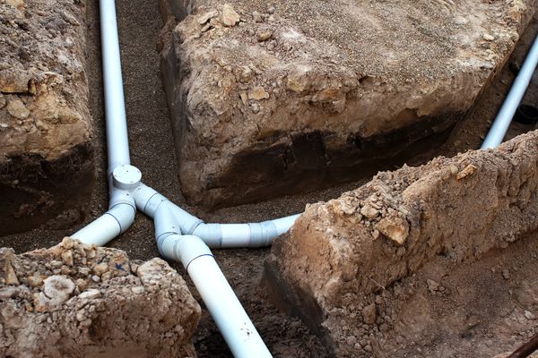 "New PVC sewer lines installed in an excavated trench, showing multi-branch drain connections and proper layout for professional sewer line repair and replacement services in North Texas."