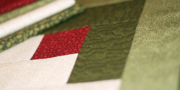 Close-up of a quilt with red and green fabric patches.
