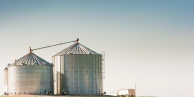 Grain storage silos on a farm under a clear sky
