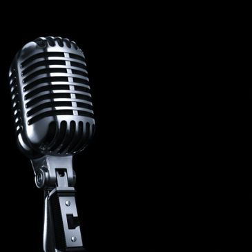 Classic vintage microphone against a black background.