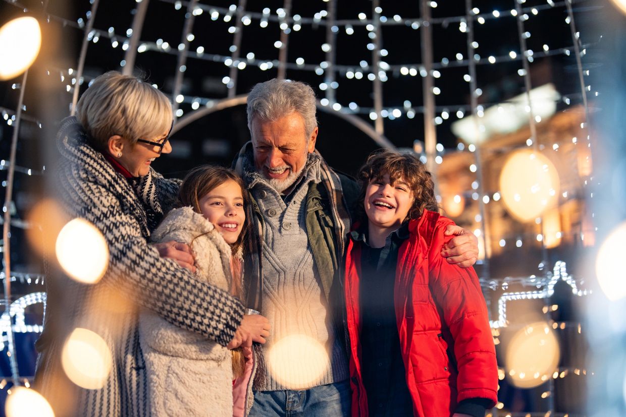 Family enjoying festive lights and warm hugs on a winter night.