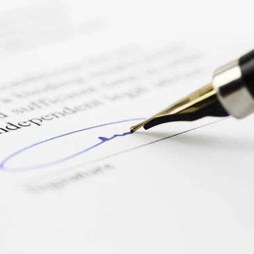 Close-up of a fountain pen signing a document with blue ink.