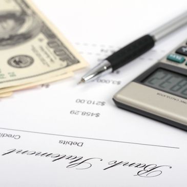 Pen, calculator, and money on a bank statement document.