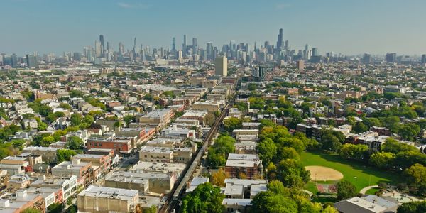 Aerial view of Chicago with a train track and green park.