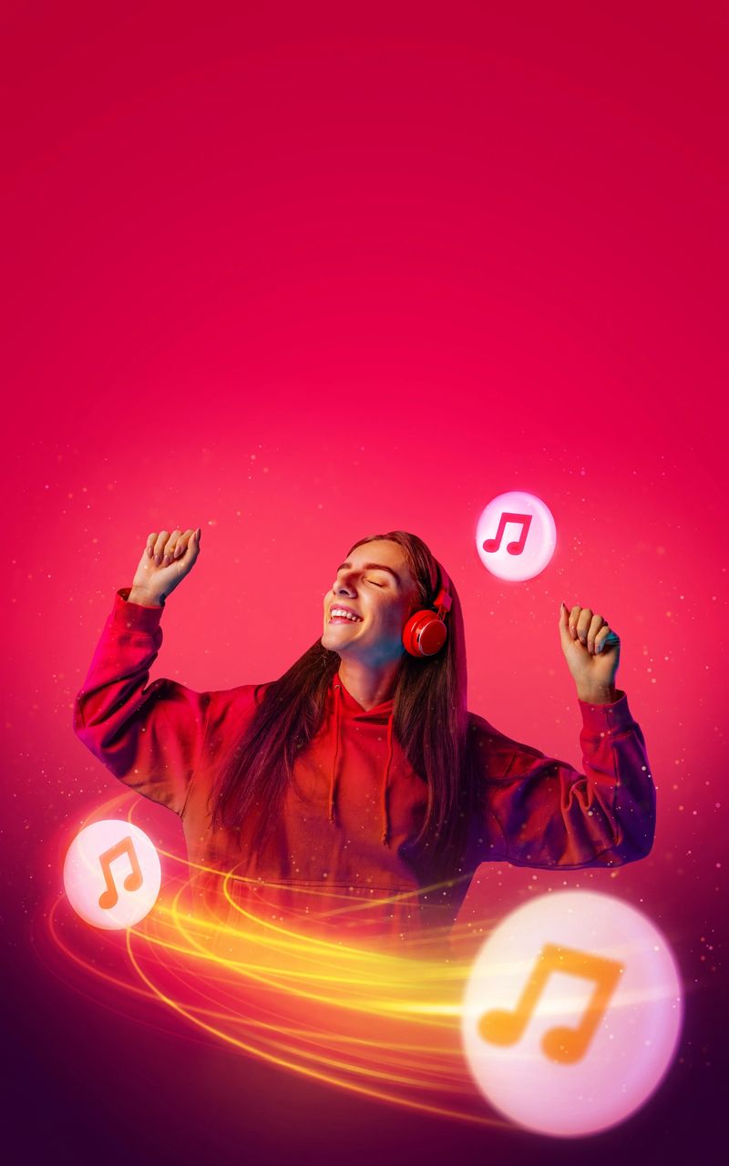 Young woman, attractive girl enjoying listening her favorite music playlist in headphones against gradient red background and flying in motion notes in bubbles. concept of hobbies, technology.