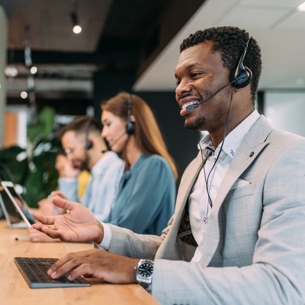 Customer service team wearing headsets, engaging with clients.