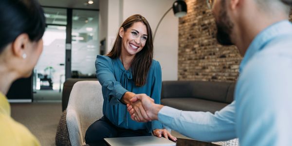 Business professionals shaking hands in a modern office setting.