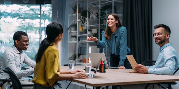 A businesswoman leads a meeting with colleagues in a modern office.