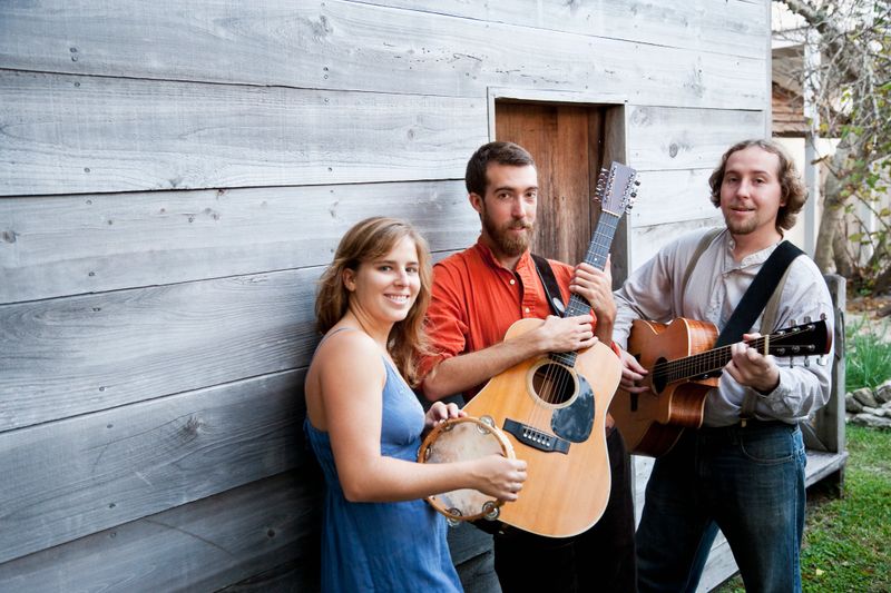 Young people, 20s, playing guitars and tambourine, focus on man in middle