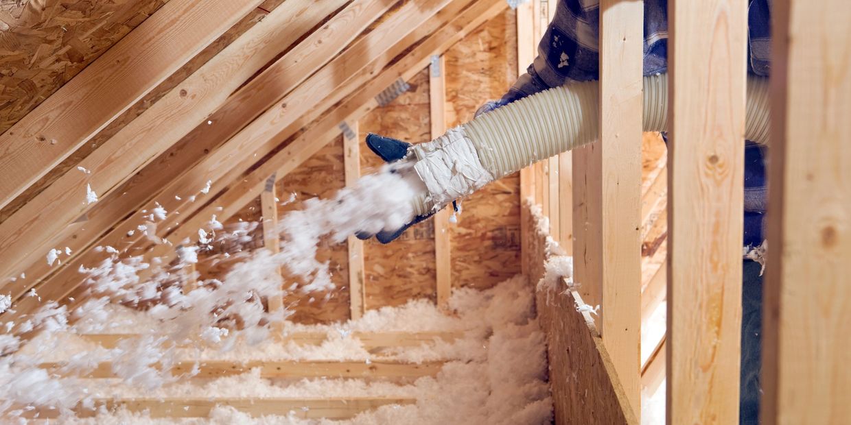 Blowing insulation into an attic space.