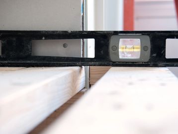 Preliminary leveling of framing studs prior to hanging Sheetrock 