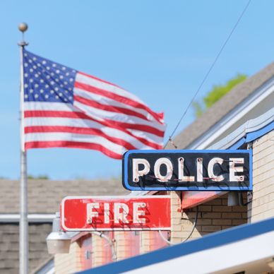 American flag above police and fire signs.