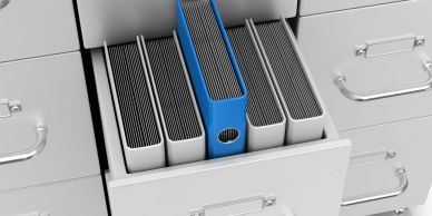 Open drawer with organizing binders, one blue.