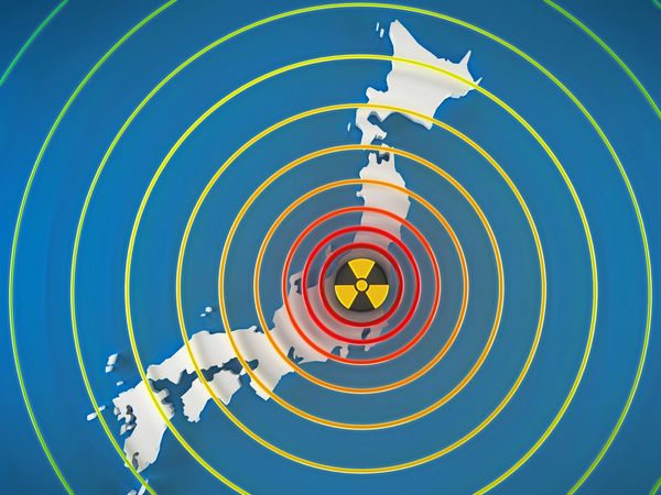 Nuclear radiation symbol centered on Japan with colored concentric rings.