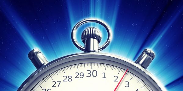 Close-up of a stopwatch glowing against a starry blue background.