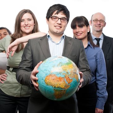 Business team posing with a globe symbolizing global teamwork.