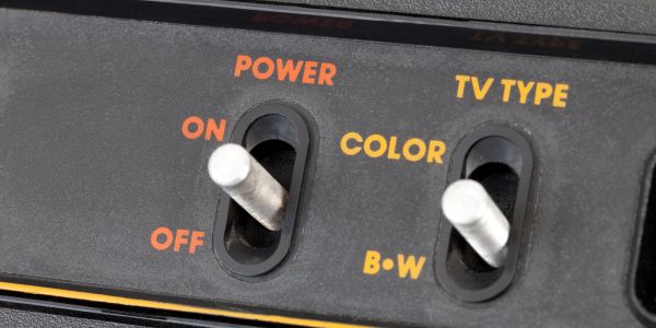 Close-up of vintage TV switches for power and color/B&amp;W settings.