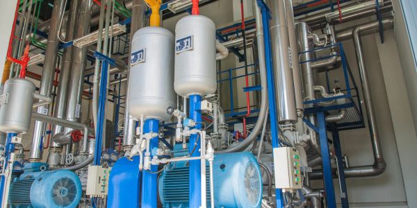 Industrial blue machinery with pipes and tanks.