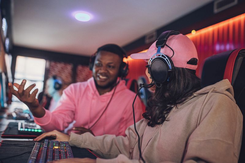 Gaming Tutorial Black Guy Gamer Explaining Game To His Friend In Gaming Centare.