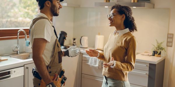 Man and woman happily discussing in kitchen.