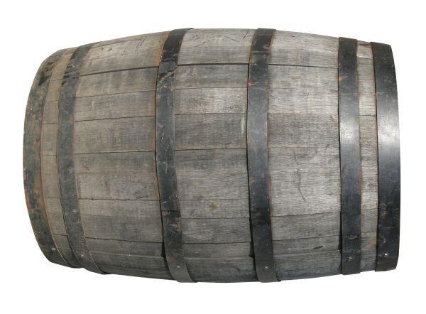 Wooden flask and cup set on a wooden table with blurred lights in the background.