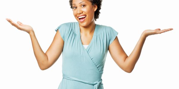 Smiling woman shrugging with hands raised in confusion or uncertainty.