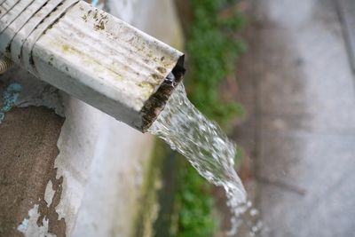 Disconnected downpipe causing water to discharge near a home foundation