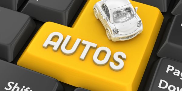 A toy car sits on a yellow keyboard key labeled AUTOS.