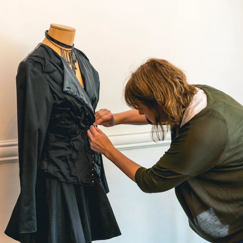 Fashion designer dressing a mannequin with black clothes