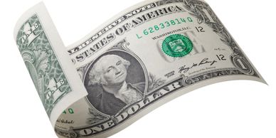 A one-dollar bill curling upwards on a white background.