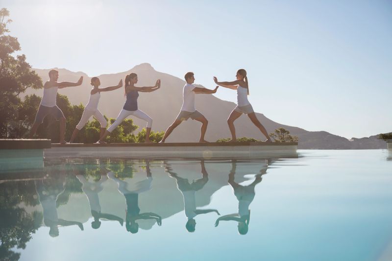 People practicing tai chi poolside