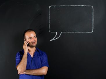 Person on phone with dialogue cloud representing business English communication training.