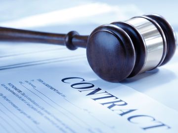 A judge's gavel resting on a legal contract document.