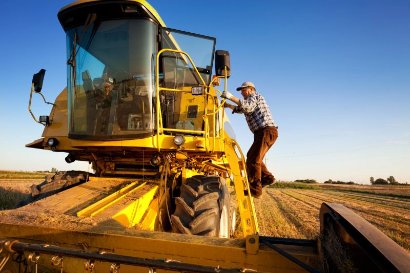Farmer enters the combine harvester. Starts harvest.