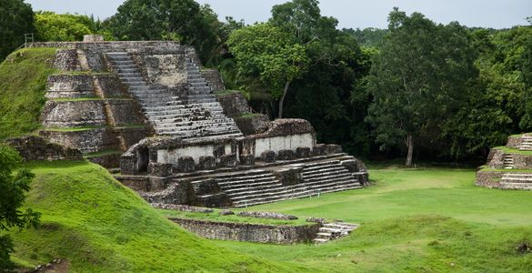 Ancient stone pyramid ruins surrounded by lush greenery.