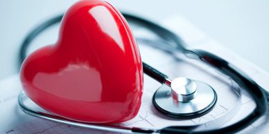 Red heart and stethoscope on ECG paper.