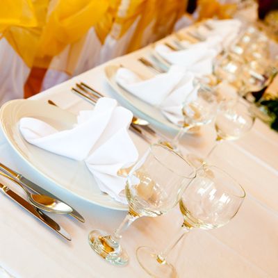 Elegantly set dining table with white napkins and glassware.