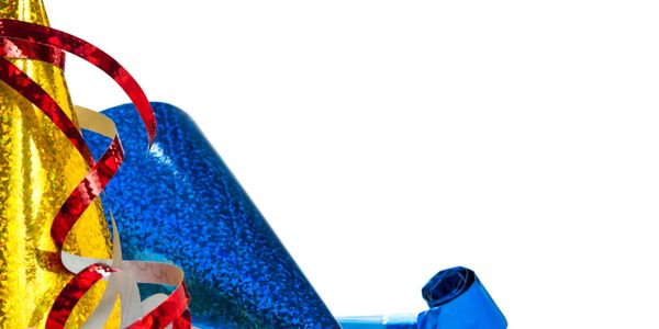 Colorful party hats and noisemakers with scattered confetti on a white background.