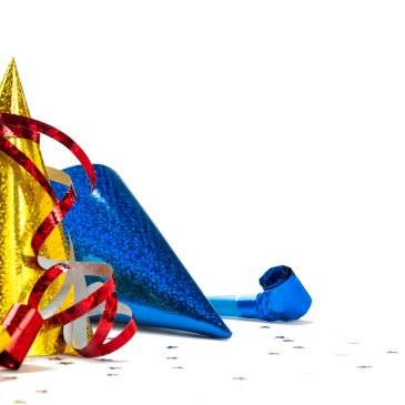 Colorful party hats and streamers on a white background.