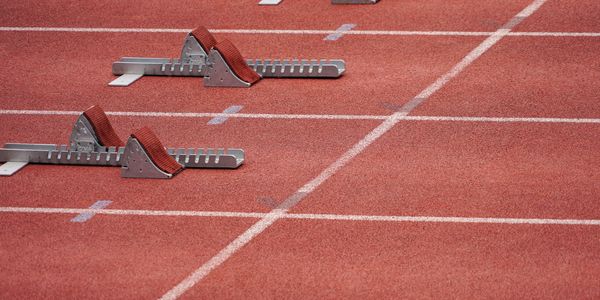 Starting blocks set on a red running track for a sprint race.