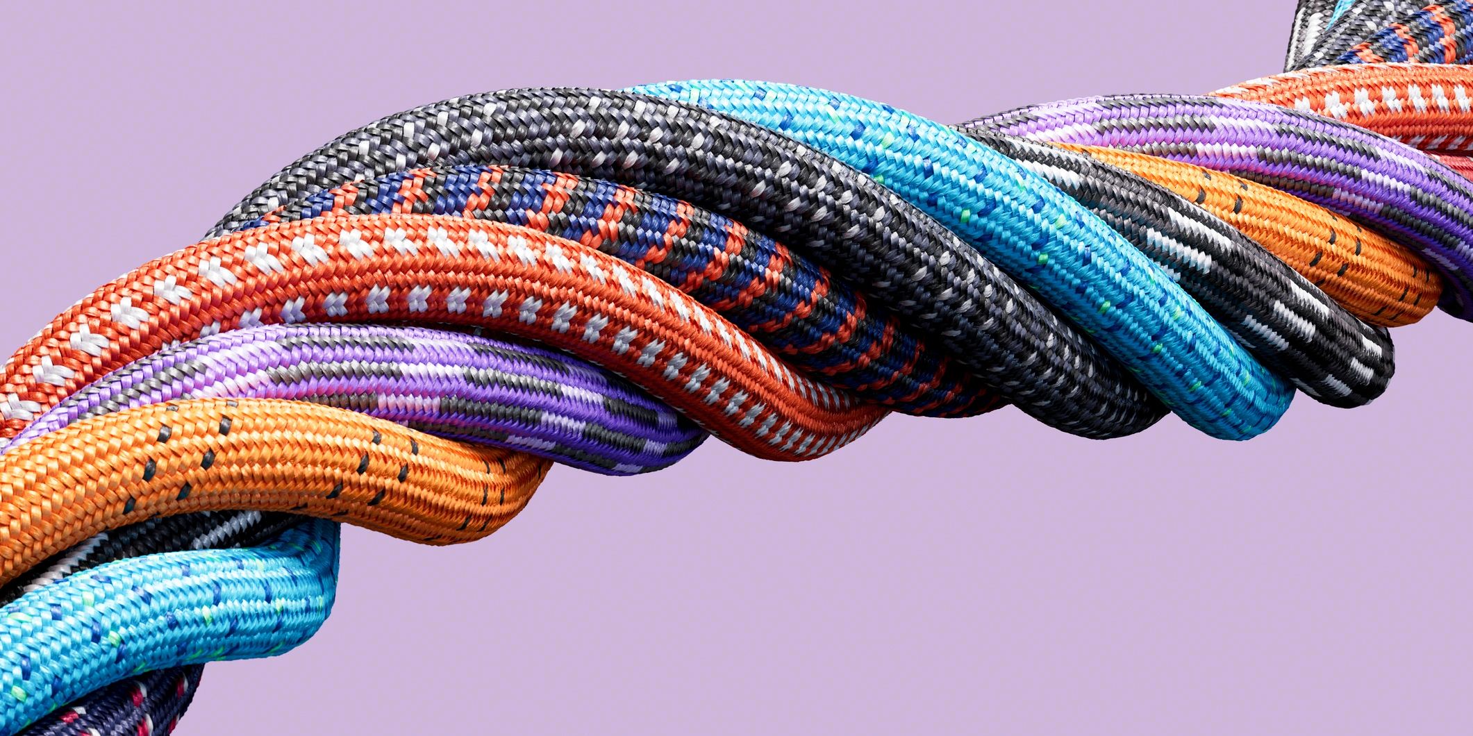 Close-up of colorful woven climbing ropes twisted together against a purple background.