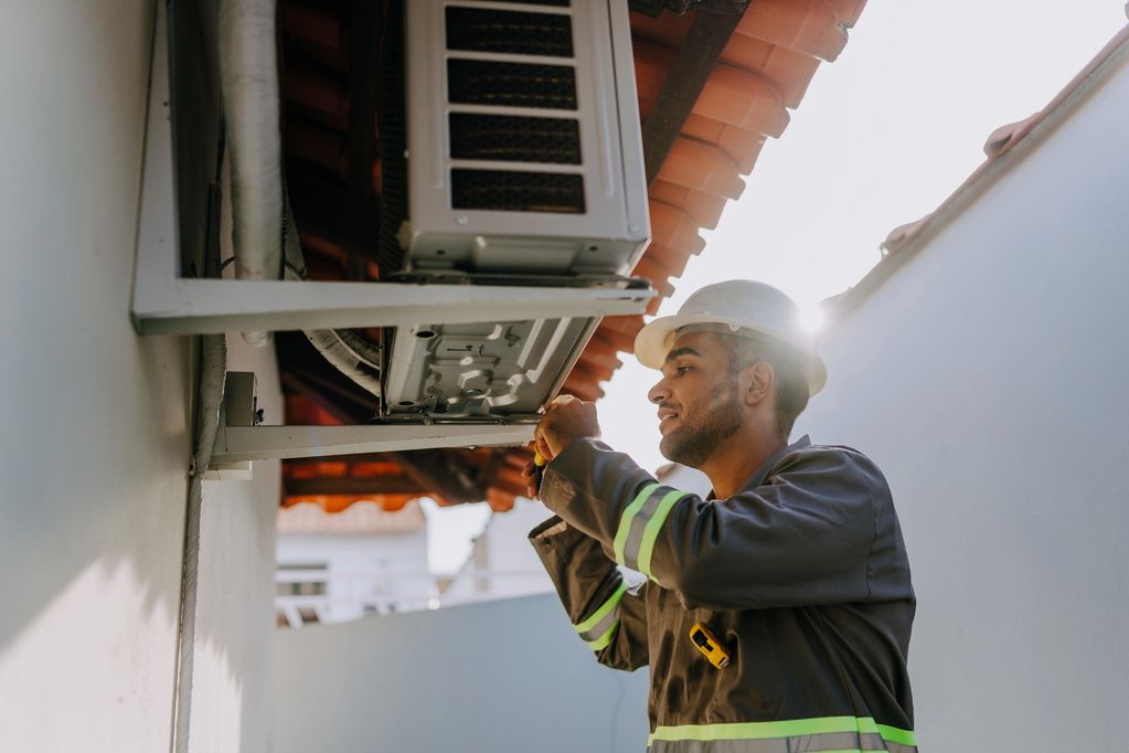 Technician repairing an air conditioning unit.