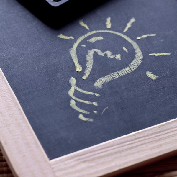 Light bulb sketch on chalkboard with calculator.
