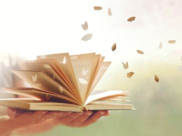 An open book with pages transforming into butterflies, symbolizing imagination.
