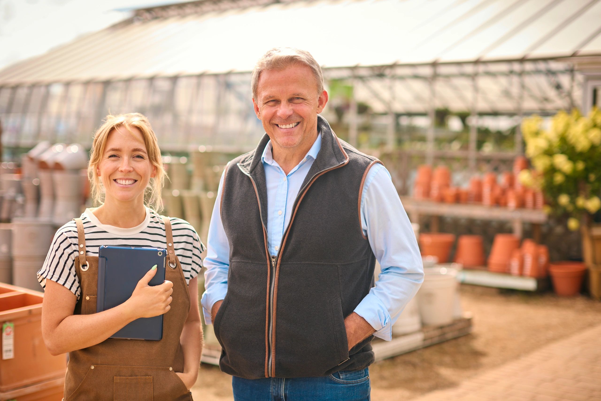 Small business owners in a garden centre reviewing their products, highlighting tax, bookkeeping and