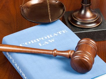Corporate law book with gavel and scales of justice.