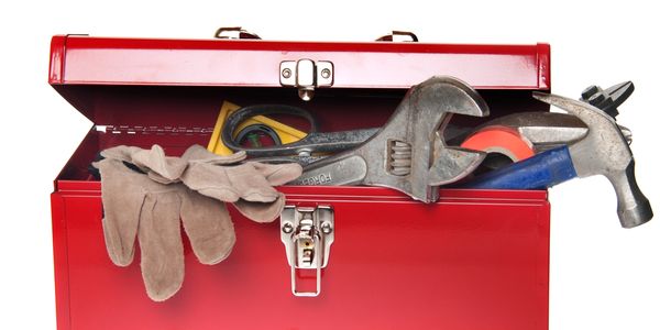 Open red toolbox with tools and gloves.