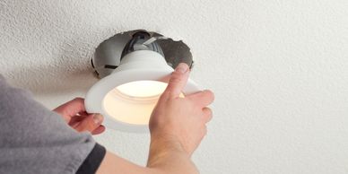 Handyman installing a recessed ceiling light fixture in a Los Gatos home.